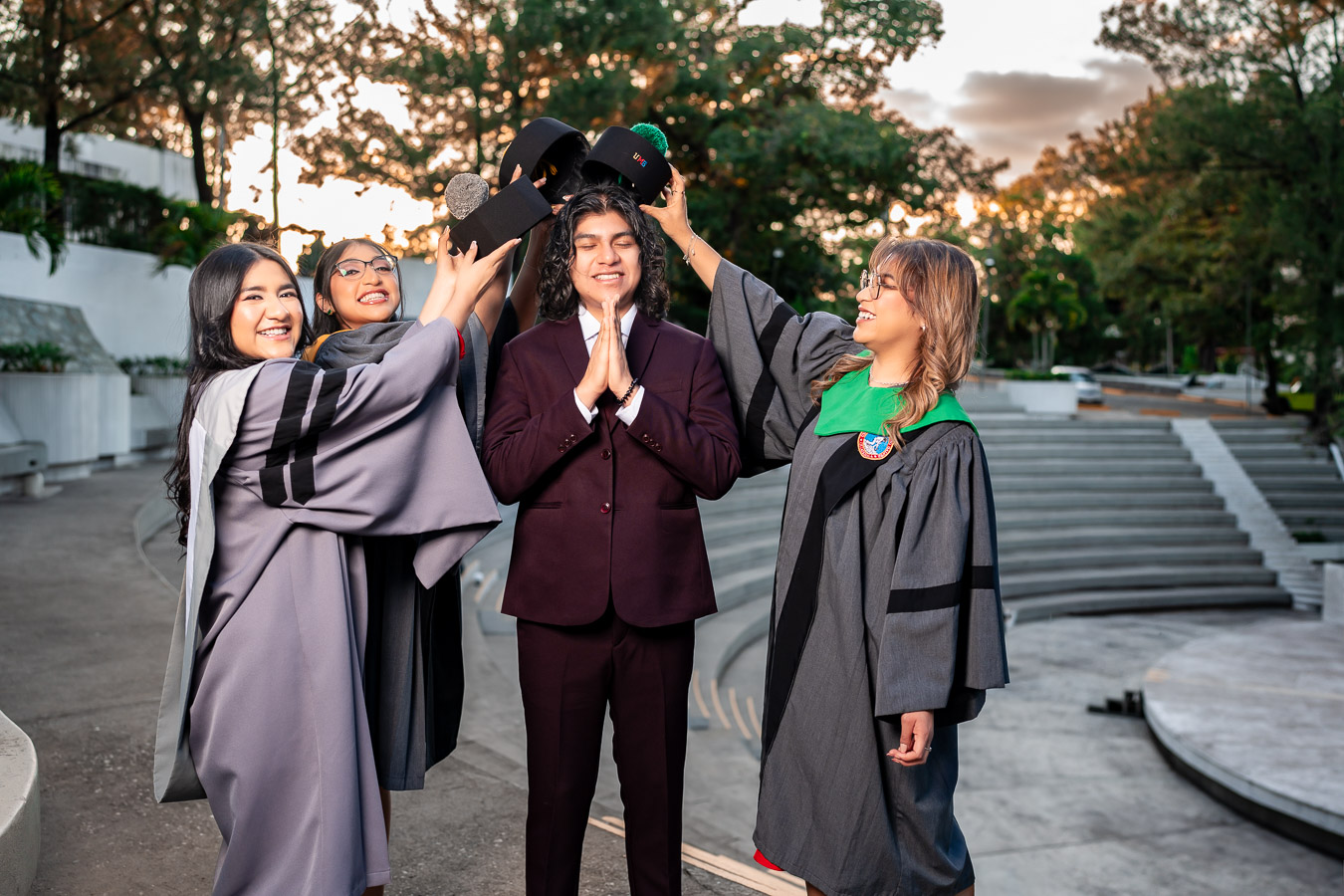 Graduada con madrinas colocando birrete a hombre